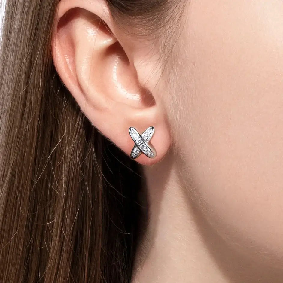 Moissanite diamond classic cross stud earrings in 925 sterling silver worn by a woman, showcasing elegant design.